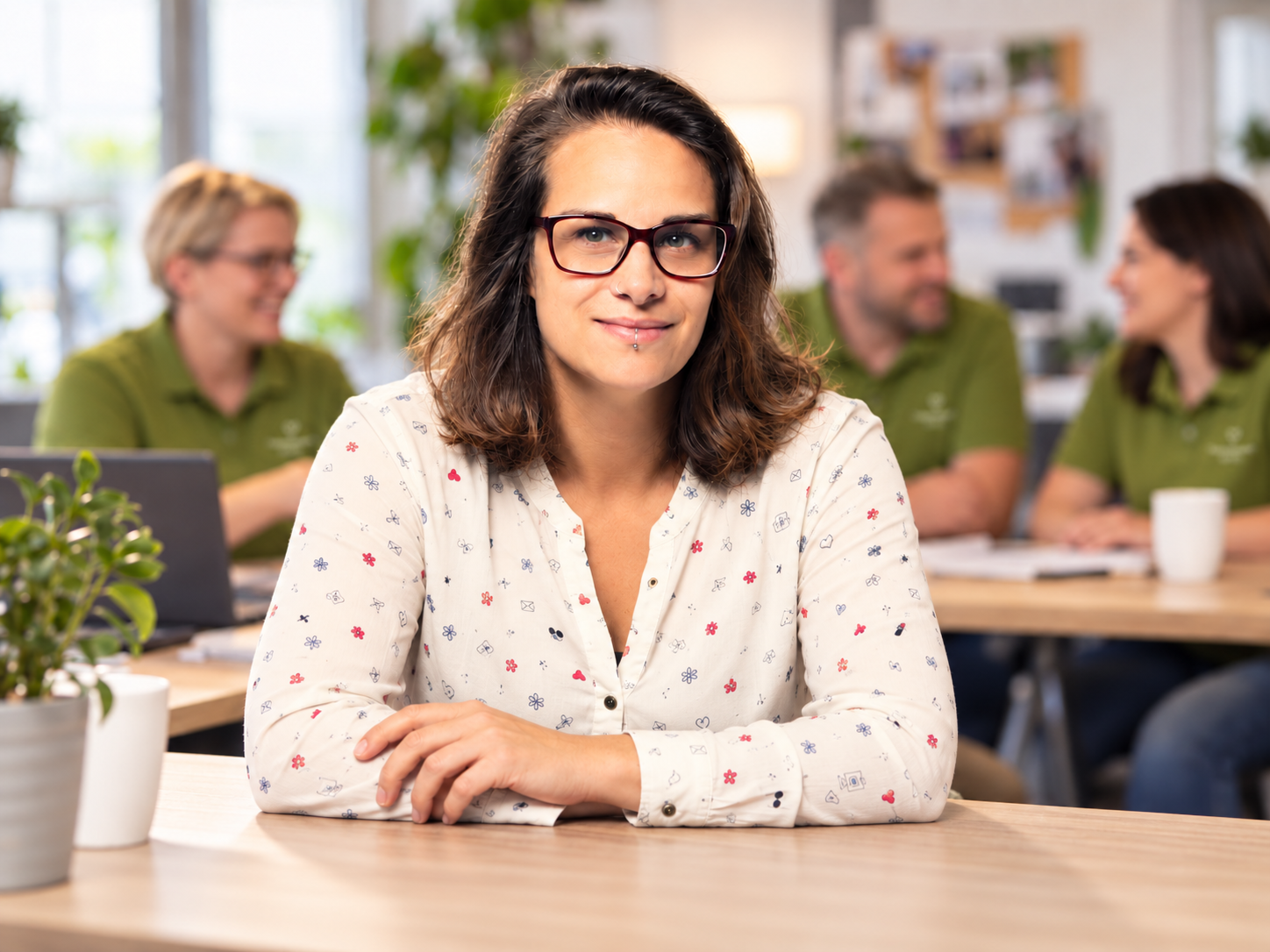 Selbstbewusstes Porträt im grünen Büroteam Gabriella Küchler mit einem Team im Pflege- und Assistenzdienst